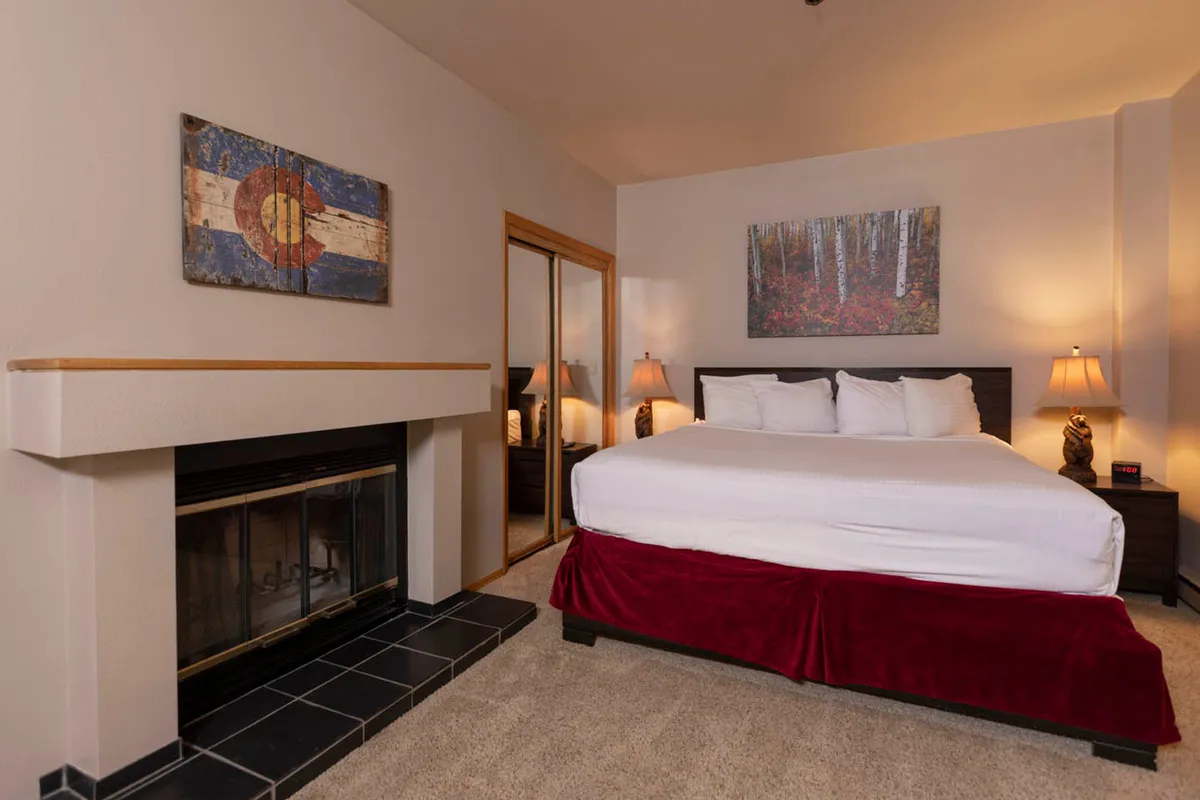 A cozy interior featuring a fireplace, comfortable bed, soothing artwork, and a warm, inviting atmosphere—perfect for winding down after a productive workday in the mountains.